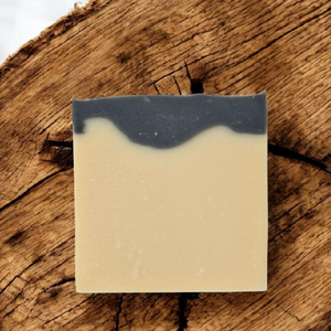 Bar of soap with a layered appearance on a wooden surface. 